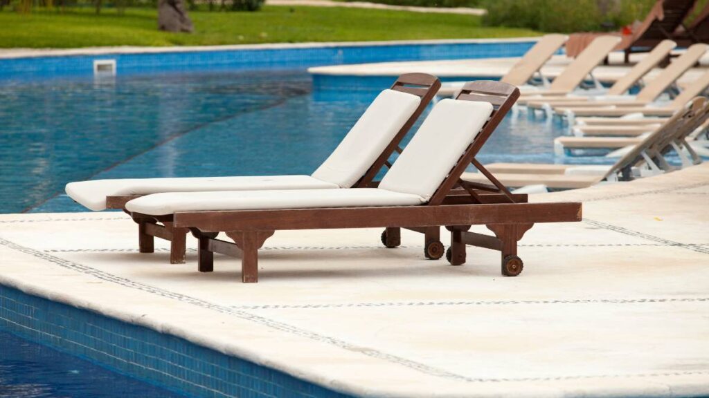 duas espreguicadeira na borda da piscina